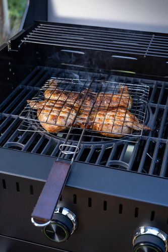 Mustang Grillkorb im Einsatz - gegrillte Hähnchensteaks auf Gasgrill, Holzgriff sichtbar, Lifestyle-Aufnahme