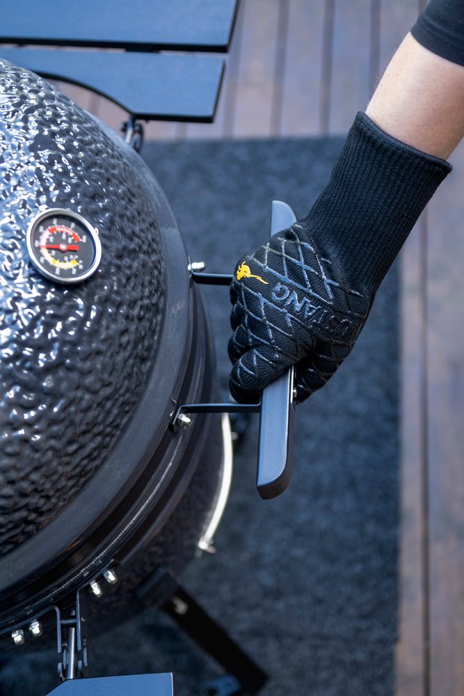 Mustang Grillhandschuh im Einsatz - Hand öffnet Kamado-Deckel, schwarzer Aramid-Handschuh mit Silikongriff