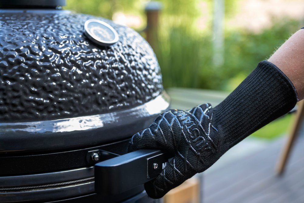 Mustang Grillhandschuh am Kamado-Grill - Hand greift seitlichen Griff, 34 cm langer Hitzeschutz bis 350°C